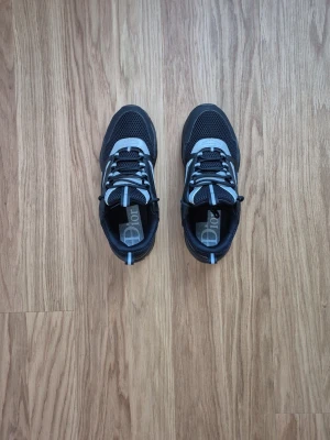 Svarta sneakers med grå detaljer med reflective  - Säljer ett par snygga svarta sneakers med grå och vita detaljer. Skorna har mesh och lädermaterial, cool design med robust sula och klassiska snörningar. Perfekta för dig som vill ha ett exklusivt och trendigt tillskott till din sneaker-samling.