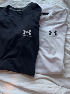 Under Armour compression shirt - Två compression shirts från Under Armour i svart och vit! Sköna till träningen nu i sommar. Kom med frågor och prisförslag 🍾