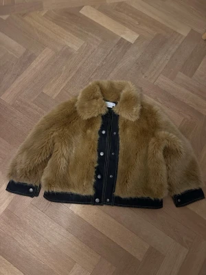 Brun pälsjacka ifrån Stella Mccartney  - Säljer en supersnygg brun pälsjacka med svarta denim detaljer och silver knappar. Jackan är i storlek 8 år och säljs för bra pris. Passar perfekt till både hösten och våren.🤎