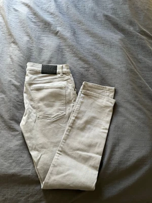 Grå jeans J.Lindeberg - Gråa slim jeans från J.Lindeberg. Jeansen har smal passform och är tillverkade i ett stretchigt bomullsmaterial som sitter riktigt bra. 31/32
