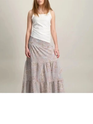 Långkjol med paisleymönster - Säljer en ljus, flowy långkjol med mönster i pastell färger. Kjolen har bred smock i midjan och flera volanger som ger ett bohemiskt och avslappnat uttryck. Perfekt för dig som gillar en romantisk och chill stil. Aldrig använd!