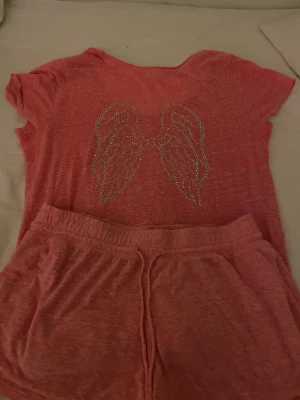 Rosa pyjamasset från Victoria's Secret - Säljer ett rosa pyjamasset från Victoria's Secret med t-shirt och shorts. Storlek M.