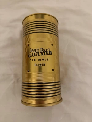 Jean Paul Gaultier Le Male Elixir 125ml - Säljer en lyxig parfym från Jean Paul Gaultier, Le Male Elixir. Flaskan kommer i en elegant guldfärgad metallburk med svarta detaljer och rymmer 125 ml. Perfekt för dig som vill ha en unik och kraftfull doft.