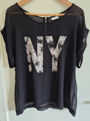 Blus/topp - Svart, transparent blus/topp med dragkedja i ryggen.