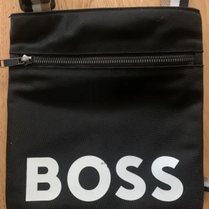 Svart boss väska  - Säljer en boss axelväska som funkar som ny. Pris kan diskuteras vid snabbköp 
