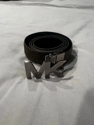 Brunt MK bälte med silverfärgat spänne -  brunt läder bälte från Michael Kors.