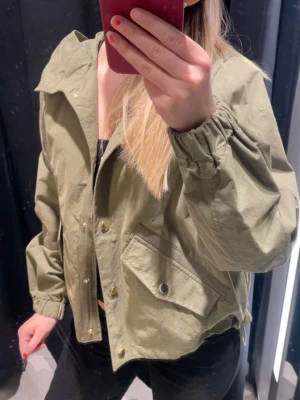 Olivgrön vindjacka med tryckknappar - Snygg olivgrön jacka som är väldigt unik