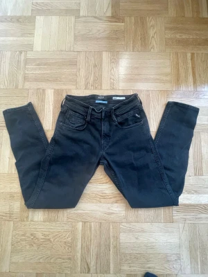 Svarta Replay Anbass - Snygga svarta jeans från Replay, modell ANBASS. Jeansen har smal passform och klassisk femficksdesign. Tillverkade i stretchigt denim för extra komfort. Märkta med 'Sustainable Lab' vilket tyder på hållbarare materialval. Kan diskutera pris