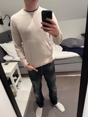 Stickad tröja från uniqlo - Säljer en ljusbeige stickad tröja från uniqlo i storlek S. Tröjan är i grymt skick, inga defekter på den. Han på bilden är 181 och väger 65 kg. Hör av er vid frågor osv! 
