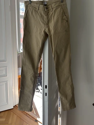 Beige chinos med raka ben - Snygga beige chinos till sommaren från NN07. Dom är något ljusare än vad dom ser ut på första bilderna, försökte få bättre ljus i sista. Använda ett fåtal gånger förra sommaren så skicket är utmärkt.