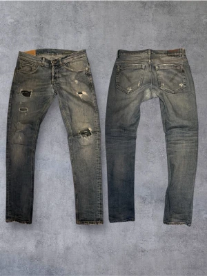 Dondup George  - Säljer ett par blåa dondup jeans med slitningar och hål på framsidan. Jeansen har klassisk femficksmodell, raka ben och detaljerade slitningar för en trendig look. Perfekta för dig som gillar en avslappnad och edgy stil.