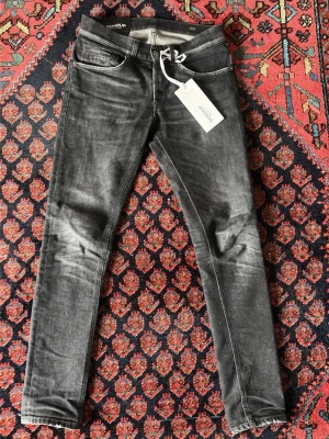 Svarta skinny jeans från Dondup - Snygga svarta jeans i slim fit-modell från Do. Jeansen har klassisk femficksdesign, smal passform och är tillverkade i ett stretchigt jeanstyg som sitter tajt längs benen. Perfekta för dig som gillar en stilren och modern look.