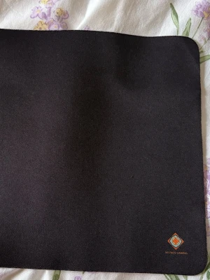 Svart musmatta DELTACO GAMING - En svart, rektangulär musmatta från DELTACO GAMING. Ovansidan är slät textil och undersidan har ett halkfritt gummimönster. Perfekt för gaming eller kontorsbruk. Diskret logga i hörnet.