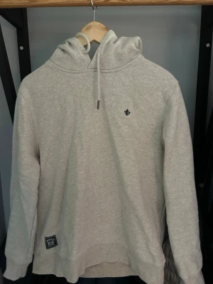 Ljusgrå hoodie från Morris - Snygg ljusgrå hoodie från Morris, perfekt nu till hösten! Storlek M. Nästan helt i nyskick. Säljer på grund av försliten. Köpt för 1400