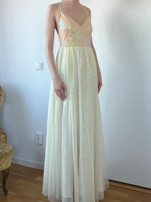 Gul balklänning - Gul balklänning från Bubbleroom, endast använd 1 gång. Mycket fint skick. Kjolen är i flera lager tunn tyll och klänningen har öppen rygg med snörning och smala korsade band. 