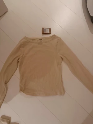 Beige långärmad topp från aimn - En enkel och stilren beige långärmad topp Tillverkad i mjuk bomull med rund halsringning och normal passform. 