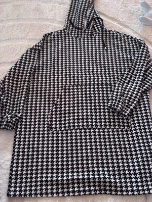 Svartvit hoodie från SHEIN - Säljer en svartvit hoodie från SHEIN med klassiskt hundtandsmönster. Hoodien har stor ficka framtill, huva och långa ärmar med resår vid ärmsluten. Tillverkad i ett mjukt och lätt material som passar perfekt för en chill och trendig look.