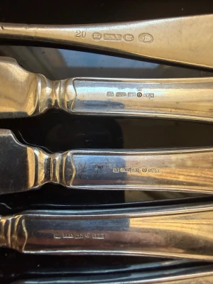 Gamla bestick i nysilver - Säljer ett set med äldre bestick i nysilver, bestående av knivar och gafflar med klassisk design och stämplar på skaften. Perfekt för dig som gillar vintage eller vill komplettera din samling med tidlösa detaljer.