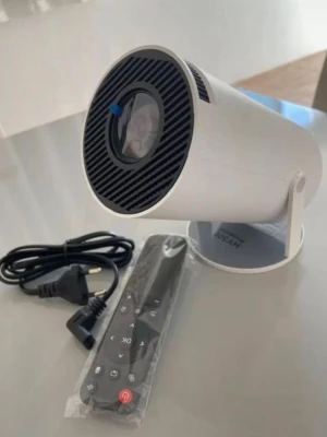 Vit mini-projektor med fjärrkontroll - Säljer en kompakt och stilren vit mini-projektor med rund form. Medföljer gör en svart fjärrkontroll och strömkabel. Perfekt för att streama film eller serier direkt på väggen. Enkel att använda och smidig att ta med sig.