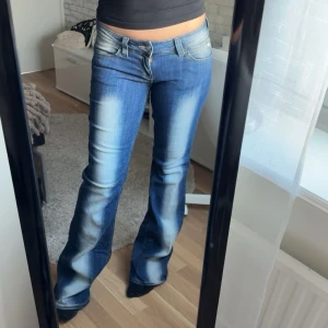 Blå bootcut jeans - Säljer ett par blå bootcut jeans med snygga slitningar och ljusa tvättade partier framtill. Midjemått: 37cm rakt över, Innerbenslängd: 80cm.