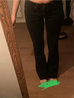 Svarta bootcut jeans med silverknappar - Säljer ett par svarta bootcut jeans från Gina med snygga silverknappar på bakfickorna. Skulle säga att de passar någon som är runt 160-165. De är inte så långa men inte för korta heller. 