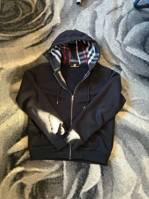 Burberry zip up - Burberry zip up i nästan ny skick. Den är knappast använd ja säljer den för den passar inte. Passar Både L och M