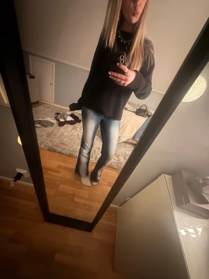 cheap monday jeans i modell booty bay - Säljer ett par blå bootcut jeans med snygga slitningar och ljus tvätt. Från Weekday i storlek