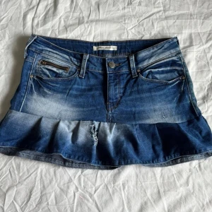 Blå jeanskjol med volang - Lite stor för modellen! Midjemått rakt över: 40 cm, S/M