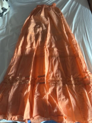 Lång orange kjol med volang - Säljer en lång kjol i en härlig orange färg. 
