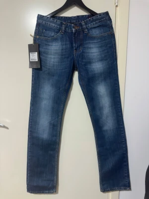 Blå jeans från Nesal - Snygga blå jeans från Nesal med raka ben och klassisk femficksmodell. Jeansen har en tvättad look med ljusare partier framtill och bak, samt kontrastsömmar. Tillverkade i bomull för en bekväm känsla och stilren passform.