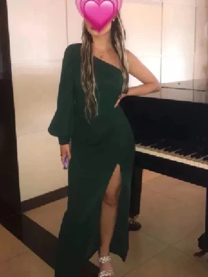 Balklänning❤️ - Stilren mörkgrön långklänning med oneshoulder-design och lång ärm på ena sidan. Klänningen har en hög slits framtill som ger en elegant touch. Perfekt för dig som vill sticka ut med en unik och trendig look. Använd 1 gång på bröllop perfekt passar perfekt på mig som är ca 1.60 plus klackar😊