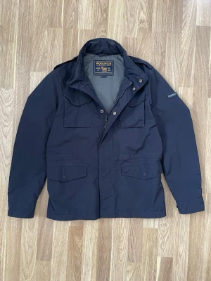 Marinblå field jacka  från Woolrich - En tunnare blå  field jacka från woolrich. Jackan har stolekn M och är i väldigt bra skick. Skriv vid frågor eller fler bilder 😃. 