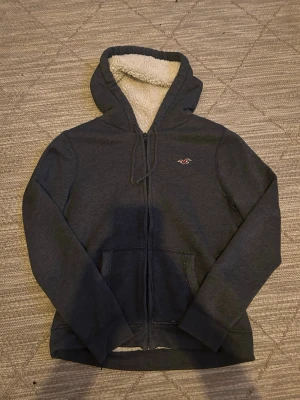 Vintage Hollister zip - Snygg marinblå zip från Hollister med fluffig fleece på insidan av huvan. Tröjan är vintage som är eftertraktat. Skicket är 10/10 då det inte finns några defekter. Storleken är S. Startpriset börjar på 599 men kan diskuteras😊😊
