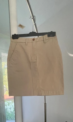 Beige GANT-kjol XS/34 - GANT-kjol i beige bomullselastan. Dragkedja framme. Motsvarar sin storlek. Använd några gånger men tvättad, ren och helt utan skavanker eller blekta ställen. Alla färgeffekter endast på bild. Längd: 44 cm