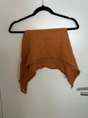 Ockragul sjal i babyalpacka - Säljer en supermjuk och lyxig trekantig sjal från Anntarah i varm ockragul färg. Sjalen är stickad i 100% babyalpacka och tillverkad i Peru. Perfekt att svepa runt axlarna för en mysig och trendig look.