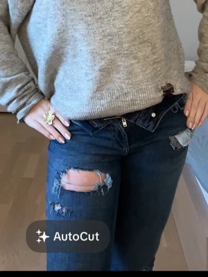 Mörkblå bootcut jeans med hål - Ett par lågmidjade bootcut jeans med hål från only