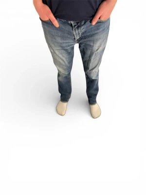 Blå Levi's raka jeans herr - Klassiska blå jeans från Levi's med rak passform och snygg slitning på låren och knäna. Jeansen har fem fickor, gylf med dragkedja och knapp samt den ikoniska röda Levi's-lappen på bakfickan. Tillverkade i slitstark denim. Lite fel storlek!! ( hör av er via funderingar )