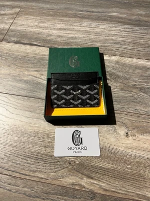 Svart korthållare  - En svart och stilren goy4rd korthållare. Perfekt att ha i fickan och kan ha kort och sedlar i