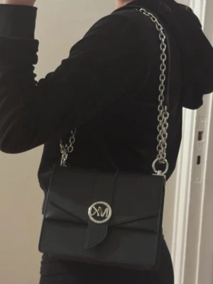 Michael Kors väska  - Säljer min fina Michael Kors väska, väskan är väl använd men fortfarande fint skick. Den har lite skav på metalldetajlerna men inget man tänker på när man bär väskan. Sedan har den lite skav på undersidan men inte heller något man tänker på. Går att både bära på axeln och runt kroppen. Köpt på Michael Kors 2023 för ca 3000kr, kvitto finns!