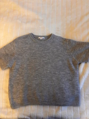 Stickad T-shirt  - Ljusgrå stickad T-shirt från Gina Young, strl 158/164. Den ser lite mörkare ut på kameran men är ljusgrå.