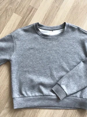 Grå basic sweatshirt från Only, stl S - En enkel och stilren grå sweatshirt från Only. Rund halsringning och ribbade muddar vid ärmslut och nederkant. Perfekt för en avslappnad look och lätt att matcha med andra plagg. Just nu fri frakt, så du betalar bara för tröjan. Jag har fler plagg ute, och hittar du något mer från min garderobsutrensning, så skickar jag allt i samma paket.