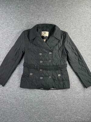 Burberry quiltad jacka – klassisk modell (Storlek UK 18 / US 16 / IT 50) - Elegant quiltad jacka i klassisk stil med bälte och dubbelknäppning. Jackan har det ikoniska rutiga innerfodret och en tidlös design som passar perfekt till både vardag och mer uppklädda tillfällen.  ⚠️ OBS: Jag är inte 100 % säker på äktheten, därför säljs jackan som okänd äkthet och är prissatt därefter. Se bilder och avgör själv.  Jackan är i bra skick med normal användning.  🔹 Märke: Burberry 🔹 Storlek enligt etikett: UK 18 / US 16 / IT 50 🔹 Modell: Quiltad jacka med bälte 🔹 Skick: Bra 🔹 Stil