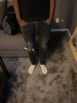 Svarta slitna jeans från Jack and Jones  - Säljer nu ett par feta svarta Jack and Jones jeans som aldrig används | W30 L32 | Längd på killen på bilden: 178 | Vikt: 67kg| Hör av er för frågor😁