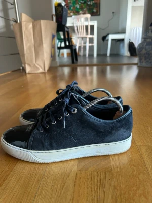 Mörkblå lanvins - Snygga mörkblå/svarta lanvins. Perfekta för dig som vill sticka ut men med klass. Nypris:5500kr knappt andvända. storlek 7 i UK passar 42 men även 43/44. Dustbag och box medföljer. Dem är i mycket bra skick. Hör av er vid funderingar!  