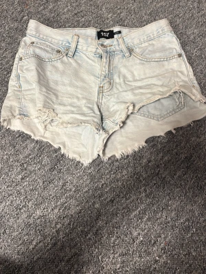 Ljusblåa jeansshorts - Säljer ett par ljusa denimshorts från 157 med rå, fransig kant och klassisk femficksdesign. Shortsen har hög midja. 