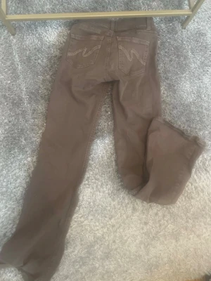 Bruna bootcut jeans Nelly - Säljer ett par bruna bootcut jeans från Nelly med klassiska bakfickor och dekorativa sömmar. Jeansen har normal midja och är tillverkade i ett mjukt bomullstyg. Perfekta för dig som gillar en avslappnad och tidlös stil. Dock slitna längst ner men inget som syns när man har på sig de men ändå mycket bra skick!!