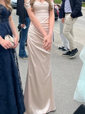 Champagnefärgad balklänning - Jätte fin och smickrande balklänning, den är champagne färgad. Jag är 1,76 och kunde även ha klackar på mig utan att den va för kort. Den har lite defekter på insidan då jag hade klackar och råkat trampa på ”släpet”. (kan skicka bilder privat) 💕😇 klänningen skickas med galge och skyddspåsen som man kan se i bakgrunden.