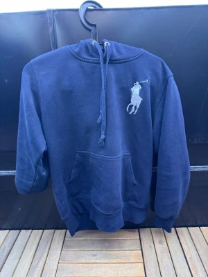 Mörkblå hoodie från Polo Ralph Lauren🙌🤩 - Snygg mörkblå hoodie från Polo Ralph Lauren med stor logga på bröstet och en broderad siffra 3 på armen. Perfekt för en avslappnad och sportig stil.