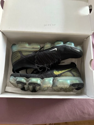 Nike Vapormax  - Nike Vapormax sneakers i svart med genomskinlig sula och guldfärgad Swoosh. Knappt använda väldigt fina och nästan som nya 