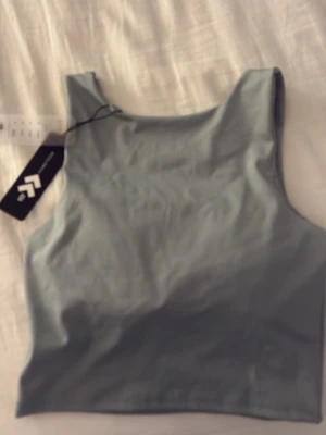 Ljusblå linnetopp från Xersion - Snygg ljusblå linnetopp från lager 157 med rund halsringning och ärmlös design. Tillverkad i ett mjukt och stretchigt syntetmaterial som passar perfekt till träning eller sommarens varma dagar. Enkel och stilren modell som är lätt att matcha.